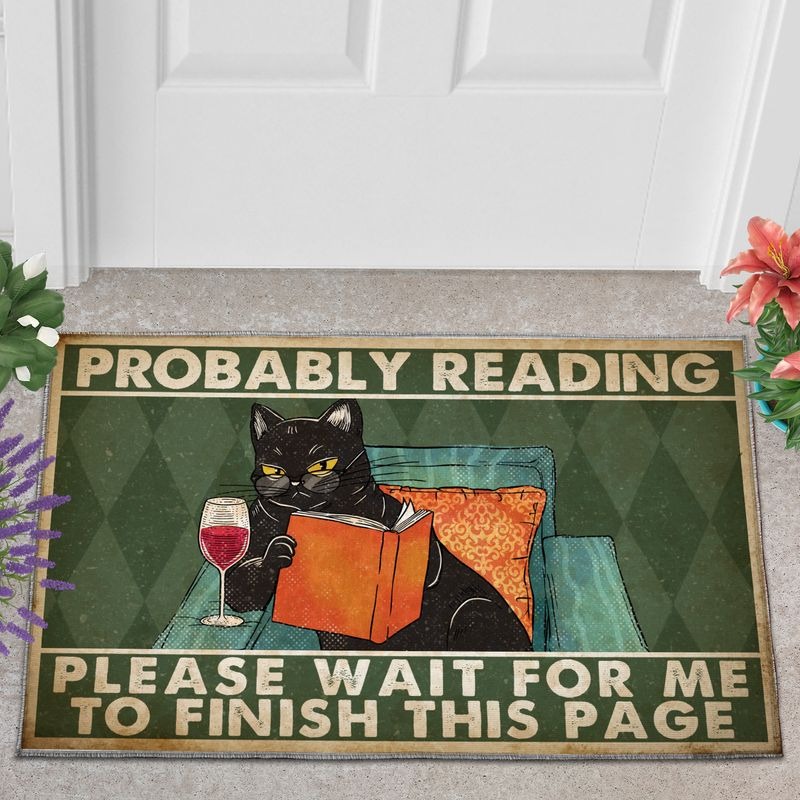 Black cat probably reading please wait for me doormat